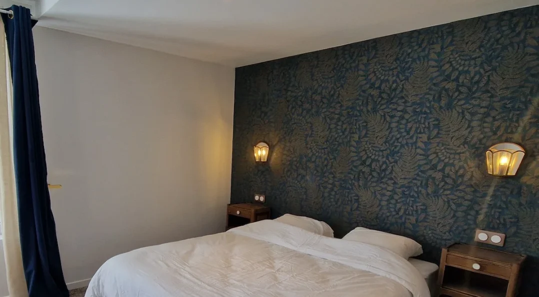 Une chambre PMR adaptée au Château. Large espace, lit double confortable, vue sur le parc. Tapisserie motif cashmere bleu foncé et beige