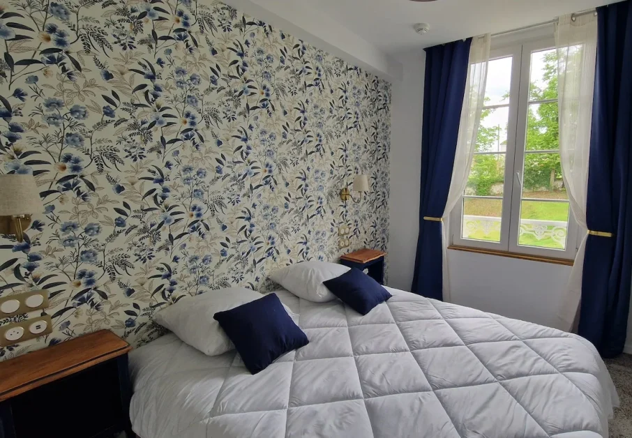 Chambre triple château Charmantes 1 Un exemple de notre chambre triple château avec vue sur le parc. Tapisserie motif ancien, mobilier vintage, lit double confortable et couchage d'appoint. Tonalité générale de la décoration : bleu marine