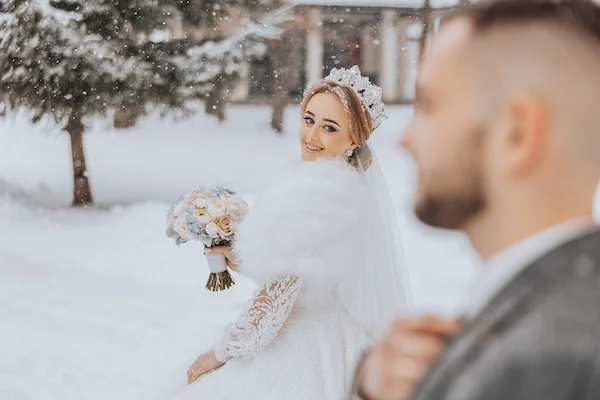 Pour un mariage d'hiver, la robe de mariée d'hiver s'impose. Une mariée qui porte une cape de fourrure et une tiare de princesse